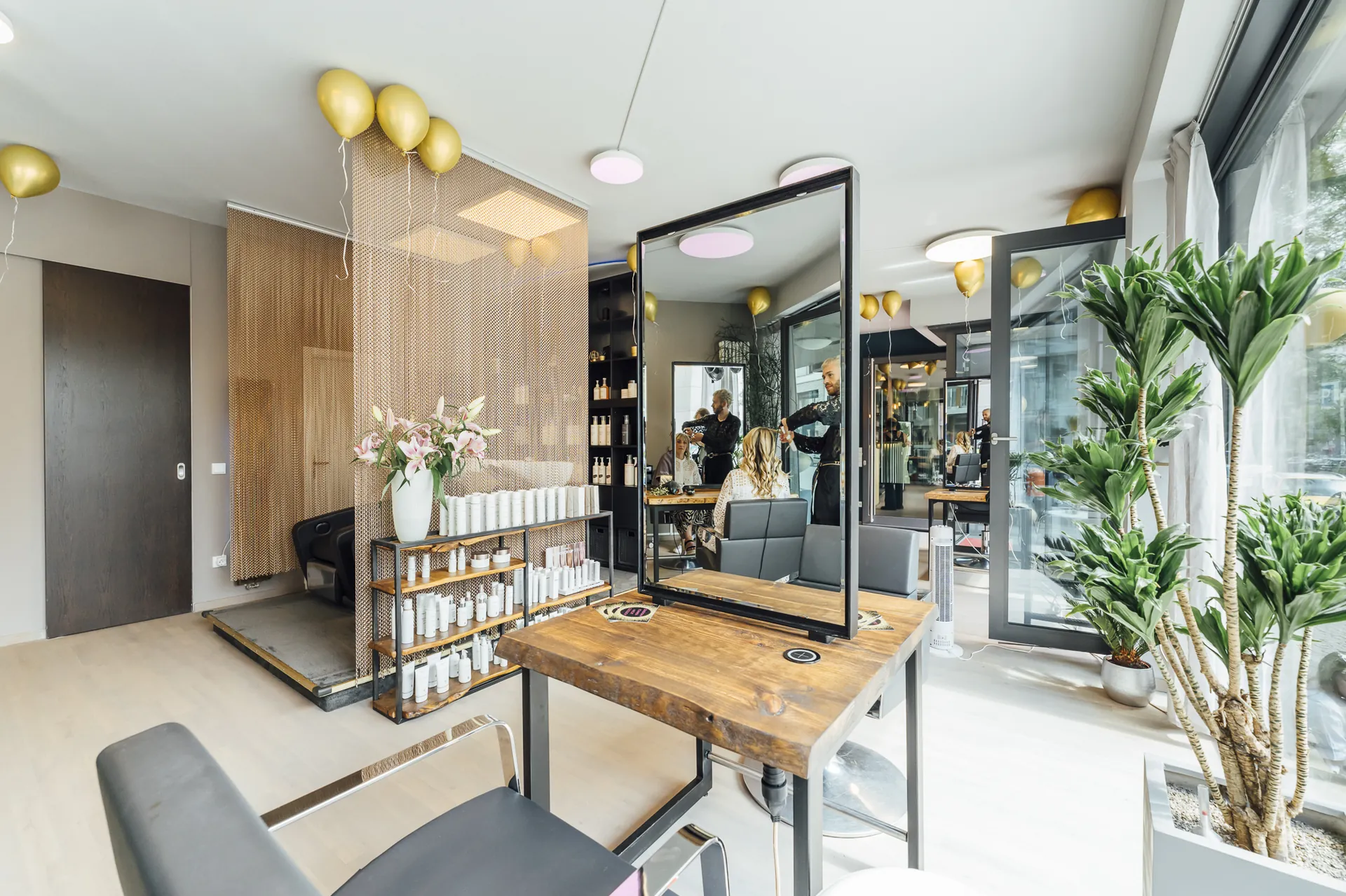 Salonraum mit Holzelementen, Pflanzen und Produktregal